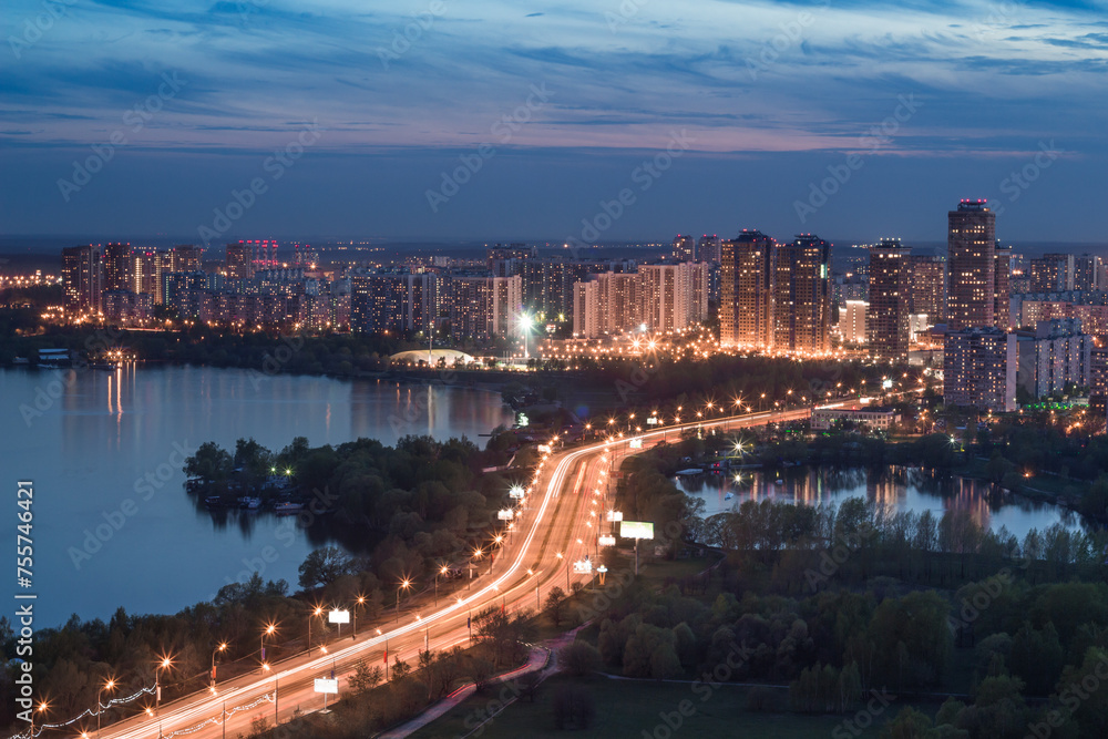 Residential illuminated district, highway, lake at summer night in Moscow, Russia
