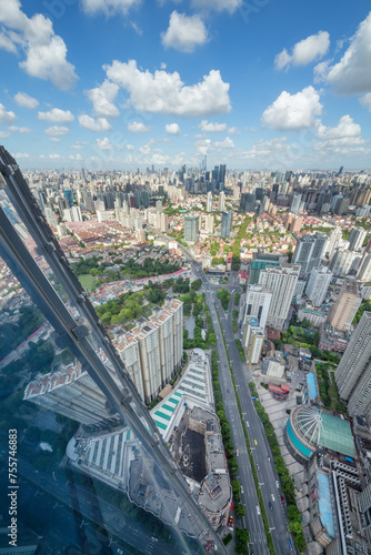 High glass building, road and residential area in big city at sunny day, top view
