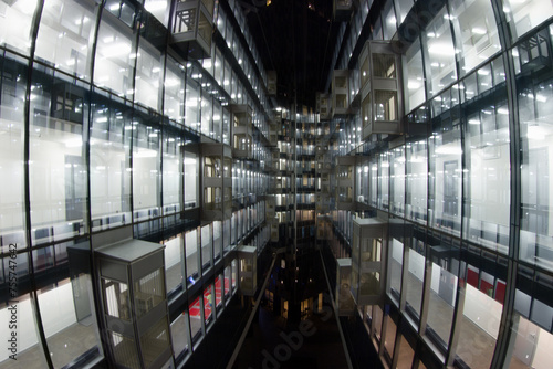 Beautiful illuminated windows with relfection in glass - modern building at night in city photo