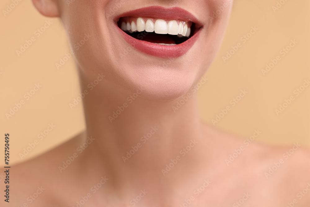 Woman with beautiful lips smiling on beige background, closeup Woman with beautiful lips smiling on beige background, closeup