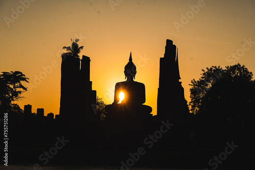 A silhouette of a Buddha st...