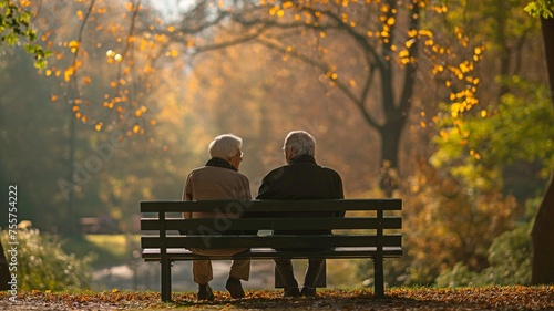 An elderly couple in the park relaxing on a bench