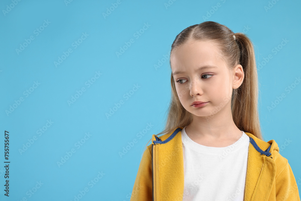 Portrait of sad girl on light blue background, space for text Portrait of sad girl on light blue background, space for text