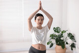 Girl practicing crescent asana in yoga studio. High lunge pose