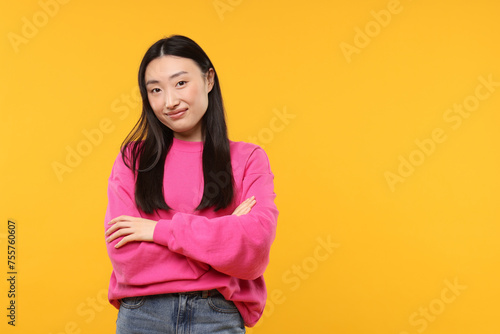 Portrait of beautiful woman on orange background. Space for text