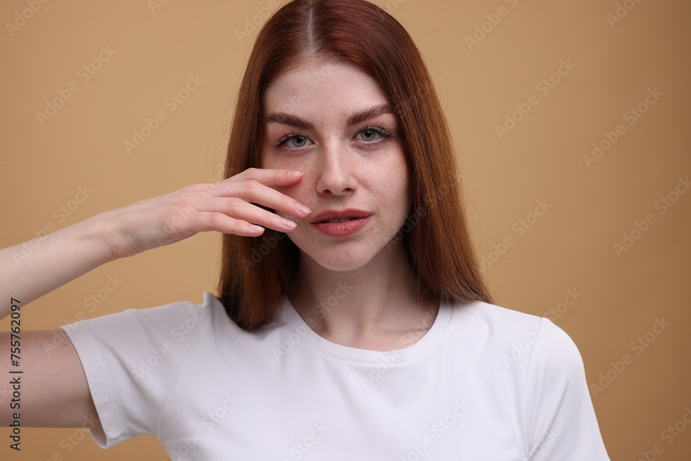 Portrait of beautiful woman with freckles on beige background Portrait of beautiful woman with freckles on beige background