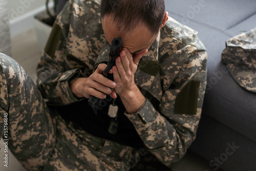 sad soldier has psychological problems holding his head in a squatting position