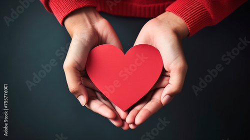 close up of woman hands with red heart on dark background, love concept