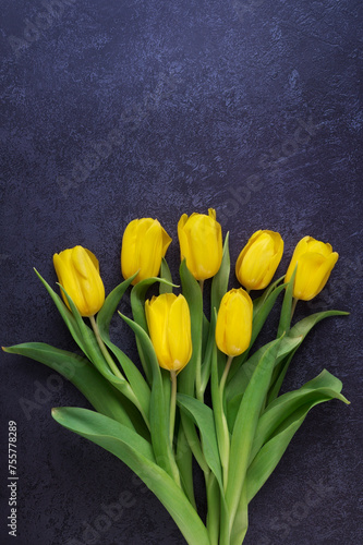 Bouquet of spring yellow flowers in dark blue background, copy space