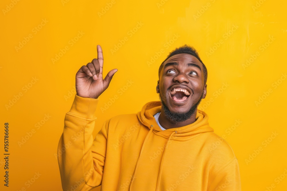 Extremely happy person looking up and pointing, yellow background. Extremely happy person looking up and pointing, yellow background.