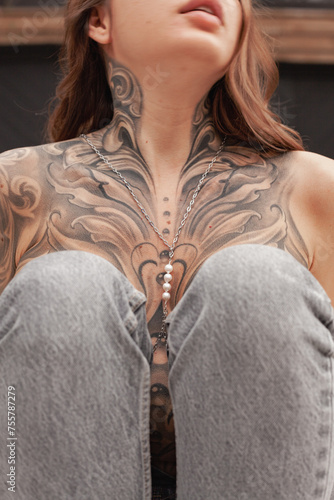 Close-Up View of a Woman Showcasing an Intricate Chest Tattoo in Daylight