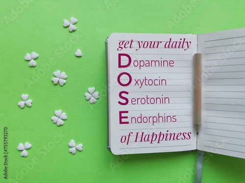 Happy brain chemicals written on a sheet of paper with decorations in the shape of heart and clover. DOSE of hormones for mental health. Dopamine, Oxytocin, Serotonin, Endorphin. Hormones of happiness