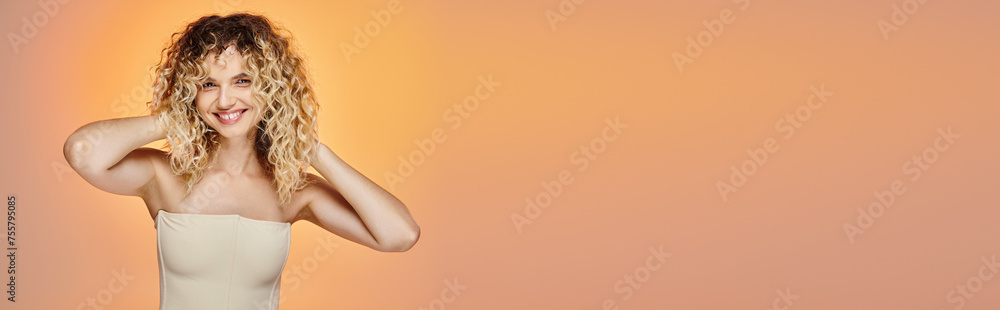 happy woman with curly hair and radiant skin posing on pink and yellow gradient, horizontal banner happy woman with curly hair and radiant skin posing on pink and yellow gradient, horizontal banner