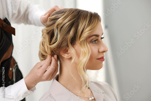 Hair styling. Professional hairdresser working with client indoors, closeup