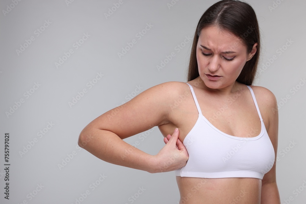 Mammology. Woman doing breast self-examination on light grey background, space for text