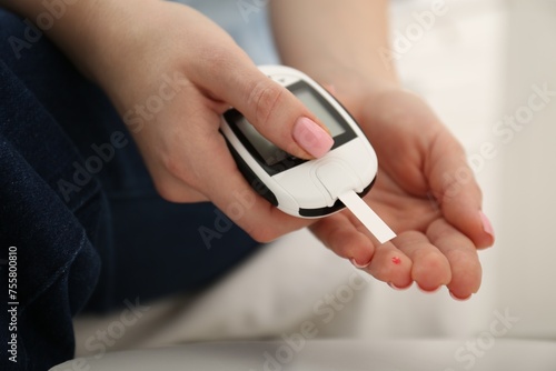 Diabetes. Woman checking blood sugar level with glucometer at home, closeup