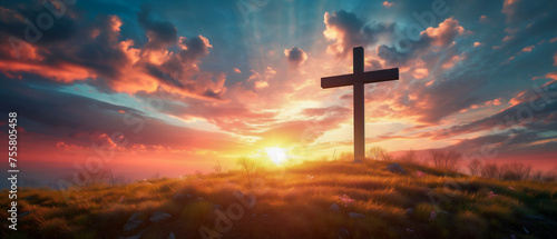 Cross is on a hillside in front of a sunset © panya7