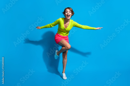 Wallpaper Mural Full length body photo of charming lady dressed green cardigan with pink mini skirt flying forward isolated on blue color background Torontodigital.ca