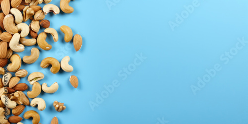 Top view dried almonds  peanuts  walnuts and cashew nuts on a blue background. Blank space for product placement or advertising text.