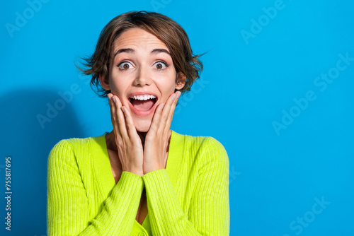 Photo of pretty impressed lady hands touch cheeks open mouth empty space isolated on blue color background