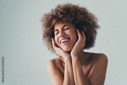 Unretouched photo of laughing woman touch face applying hydrating cream for smooth skin isolated over pastel color background