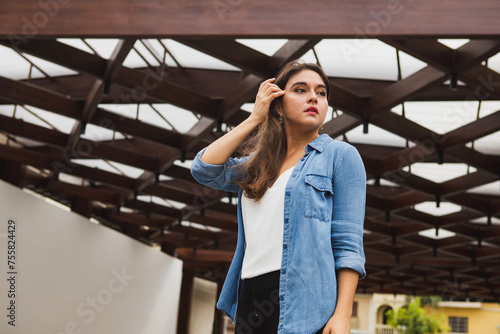 Young woman touching her hair looking to the left