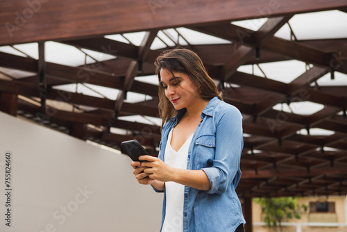 Young woman typing on cell phone