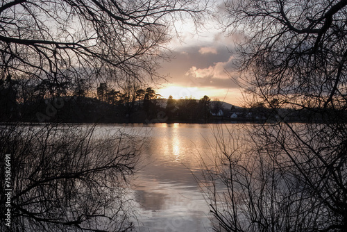 sunset and orange sky reflecting in Petersfield Heath Pond Hampshire England 