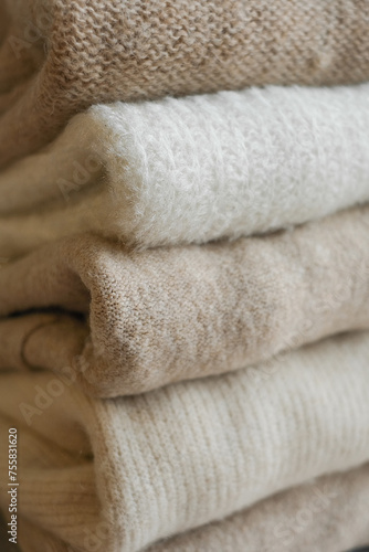 woolen clothes of light shades, folded on a white background mockup © Irina