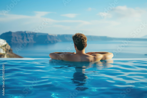 A man enjoys the serene view of a seascape from an infinity pool, embodying relaxation and luxury travel.