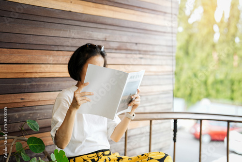 Close up teenage girl holding and reading book or magazine in reading room at home, copy space concept.
