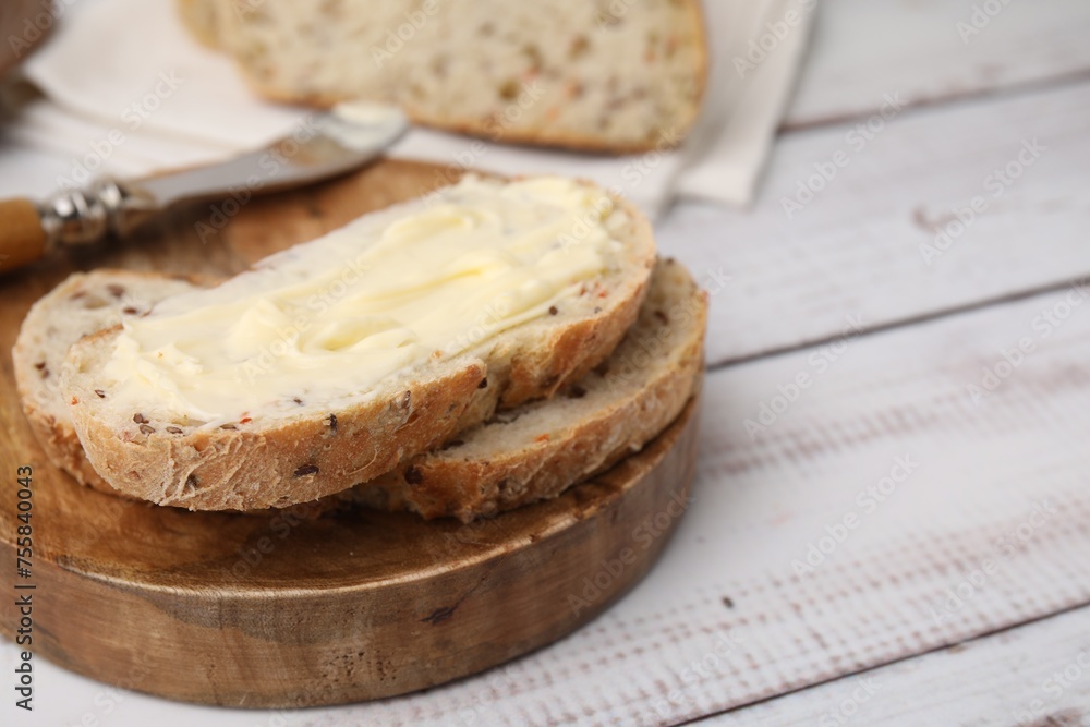 Slices of tasty bread with butter on white wooden table, closeup. Space for text Slices of tasty bread with butter on white wooden table, closeup. Space for text