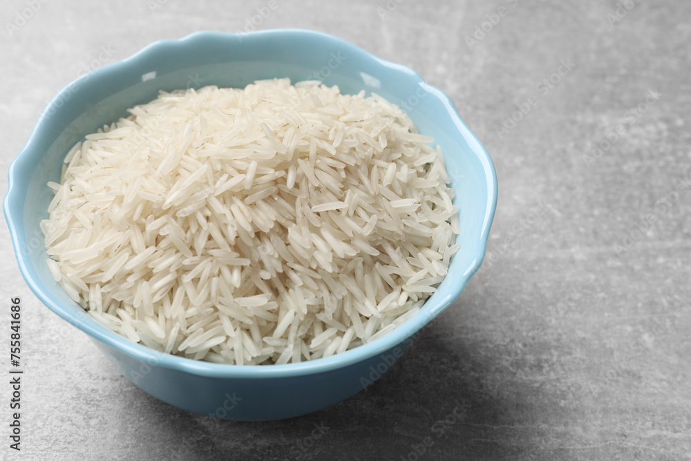 Raw basmati rice in bowl on grey table, closeup Raw basmati rice in bowl on grey table, closeup