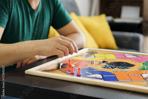 a young man playing ludo on a table photo