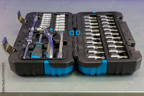 Universal tool box, tool kit closeup with set of hex, torx and screwdriver bits, and various sizes of ratchet wrench sockets photo