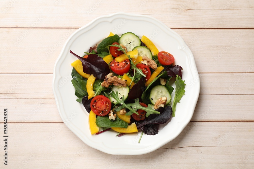 Tasty fresh vegetarian salad on light wooden table, top view Tasty fresh vegetarian salad on light wooden table, top view