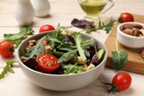 Tasty fresh vegetarian salad on light wooden table, closeup