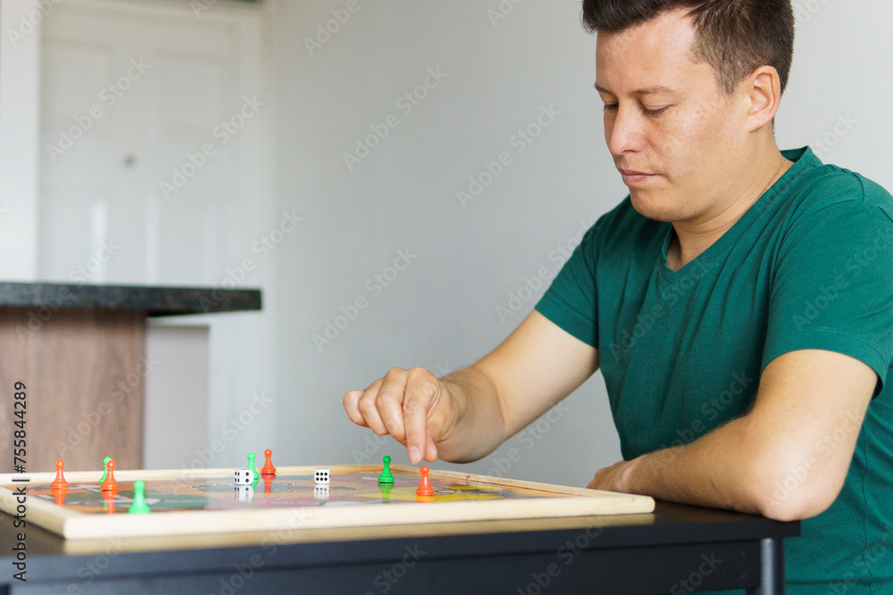 a man playing ludo at a table
