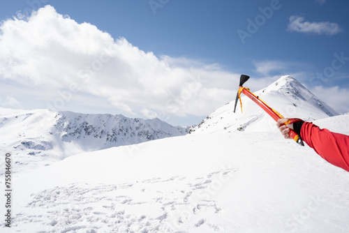 Ice ax directed towards the mountains.