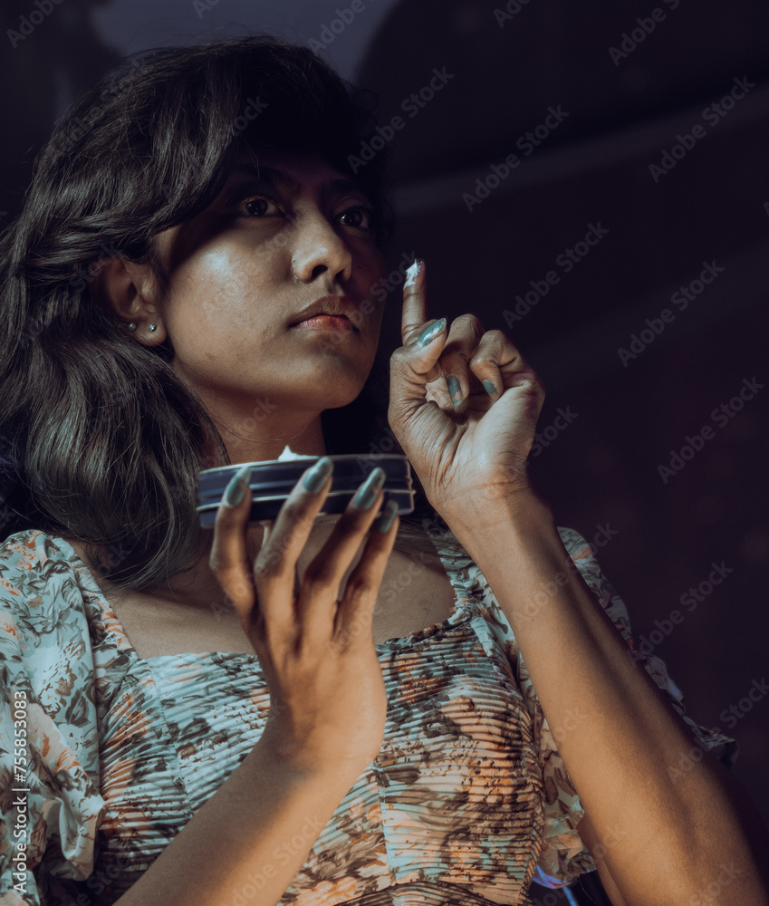 A woman is applying makeup in front of a mirror A woman is applying makeup in front of a mirror