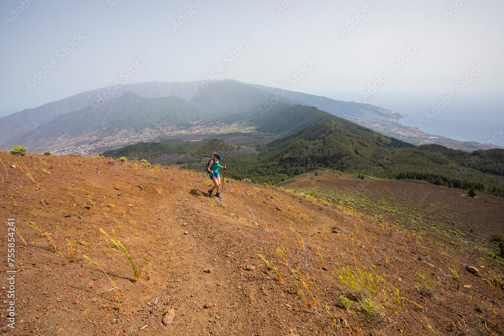 A young woman walking towards Birigoyo peak, La Palma Island, Canary Islands.