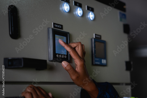 Hand of Technician is touching a switch on a power box