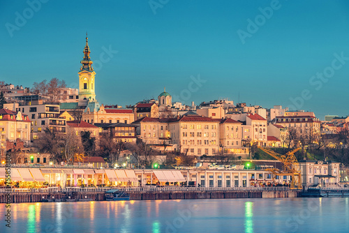a panoramic vista of the city's old town and fortress and ships passing by a Sava river © EdNurg