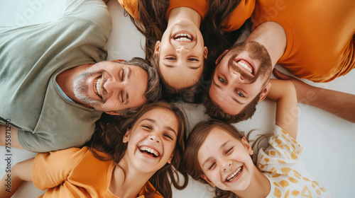 Grandfather, dad and three granddaughters lie together and laugh.