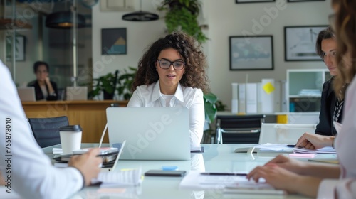 The young businesswoman smiles as she works on her laptop in the office