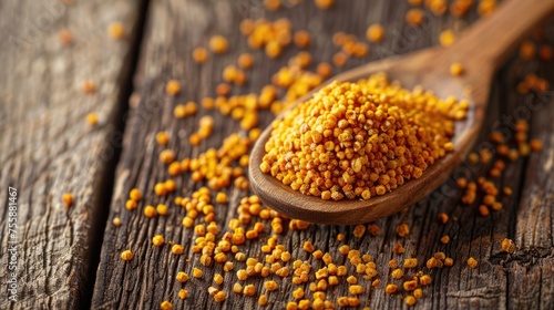 Raw Bee Pollen - A Healthy Alternative to Honey. Natural Food Source in Yellow Spoon on Wooden Background photo