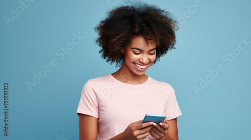Young woman smiling and holding her smartphone on a blue background