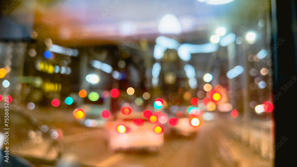 Defocused city lights at night. Blurry bokeh shiny sparkles of red and golden lights of traffic. Cars behind bus window. film grain pixel texture. soft focus. blur. 