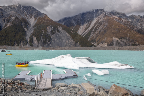 landscape of tasman glacier with boat arriving at jetty in new zealand in spring photo