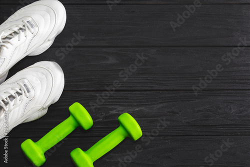 running shoes with dumbbells on a black background. Healthy lifestyle